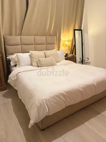 Queen upholstered bed with headboard in beige - good condition