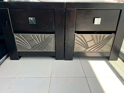 Pair of dark wood bedside tables with carved drawer fronts