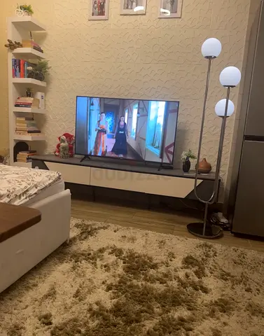 Modern low TV and TV cabinet with decorative book shelving and floor lamp