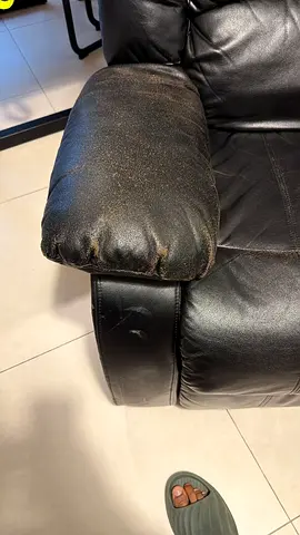 Used black leather reclining armchair — worn armrest, functional