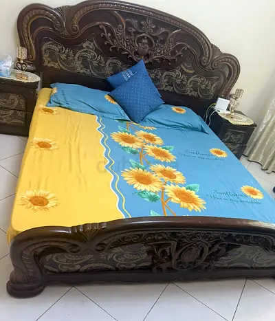 Ornate carved wooden double bed with matching bedside tables