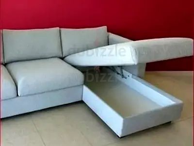 Light grey L-shaped storage sofa with pull-out compartment
