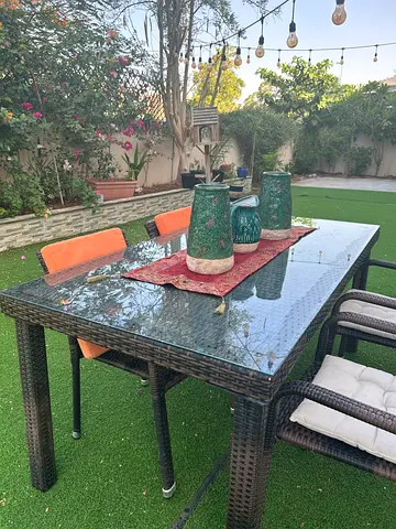 6-seater outdoor rattan dining table set with glass top and cushions