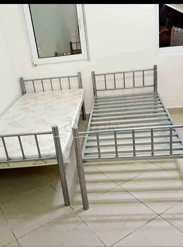 Two single metal bed frames with one mattress