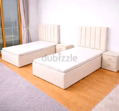 Pair of single upholstered beds with mattresses and bedside drawers