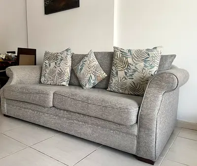 Three seater grey fabric sofa with dark wood coffee table
