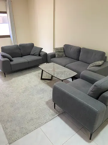 Grey L-shaped Fabric Sofa with Coffee Table and Rug - Good Condition