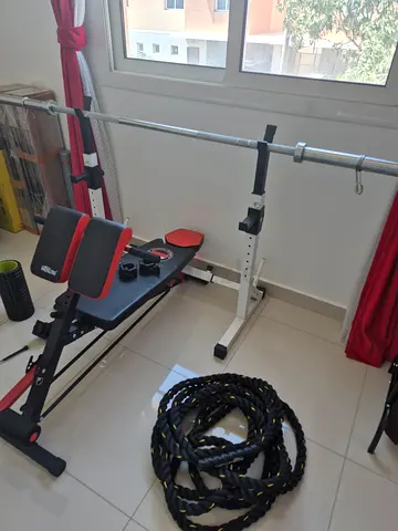 Adjustable decline weight bench with barbell/squat rack, battle rope, Olympic weights set and misc