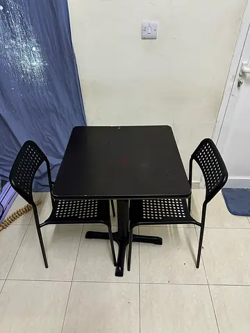 Compact black dining table with two matching chairs - good condition