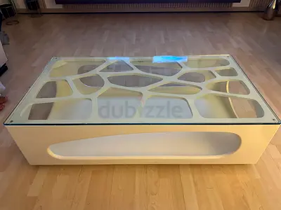 Glass-top modern coffee table with sculpted base 130/70/40