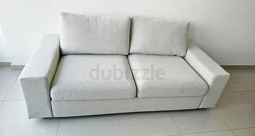 Beige 2-seater fabric sofa bed in good condition
