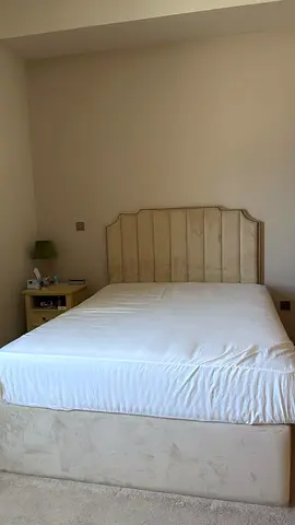 Beige upholstered double bed with headboard and storage base