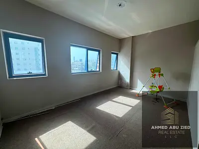 Largest studio in Ajman Rashidiya 2, Falcon Tower, semi‑separate kitchen, built‑in wardrobes, central A/C, modern finish, near services, rent yr