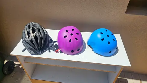 Three bike/helmet helmets — adult and kids, gently used