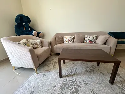 Light beige 3-seater sofa and a matching single sofa with coffee table. Decorative pillows included.