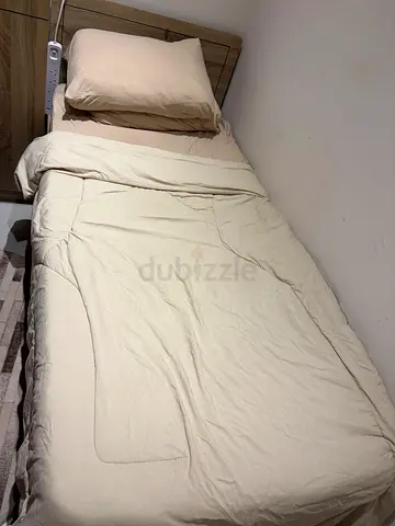 Single bed with a bedside table, dressing table, and wardrobe
