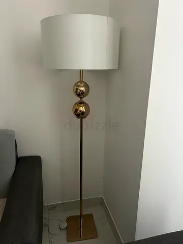 Gold standing floor lamp with white drum shade