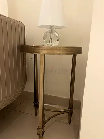 Round metal side table with antique brass finish