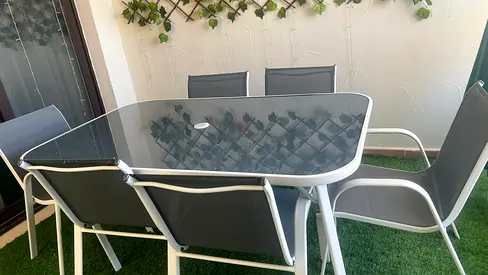 Outdoor glass-top dining table with 6 grey sling chairs