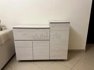 White Wooden Storage Cabinet with Shelves and Pull-Out Trays. Top is marble