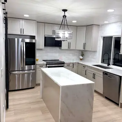 Modern white kitchen with marble island and stainless steel appliances