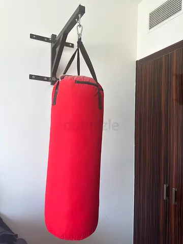 Red hanging punching bag with wall mount (used) and boxing gloves