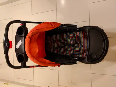 Lightly used orange baby stroller with tray and cup holders