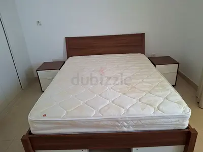 Queen bed frame with mattress and two bedside tables - good condition