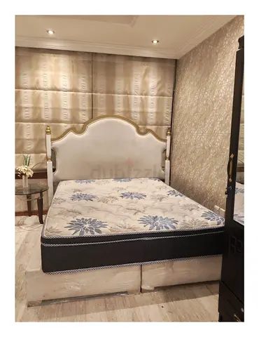 Queen-sized bed frame with mattress and storage base, elegant upholstered headboard