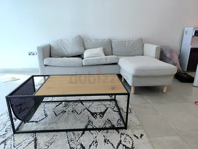 Light grey L-shaped sofa with chaise and matching coffee table,