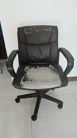 Used black office swivel chair with worn upholstery
