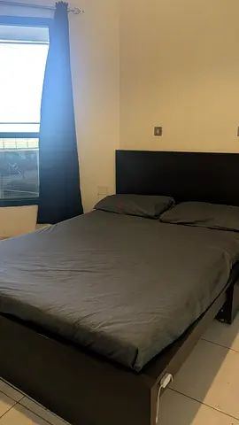 Queen bed frame with headboard in dark wood, includes mattress base
