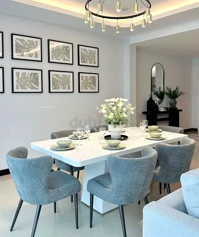 Modern white marble-look dining table with 6 grey upholstered chairs