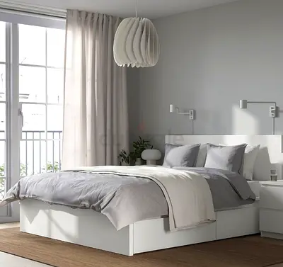 White platform bed frame from Ikea with 2 storage boxes