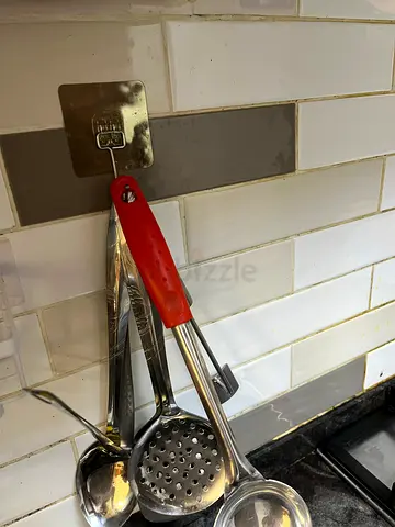 Set of 4 stainless steel kitchen ladles and skimmer with red-handled tongs.Storage boxes