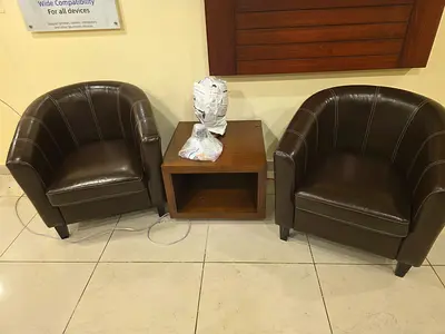 Set of 2 brown leather tub chairs with small wooden side table