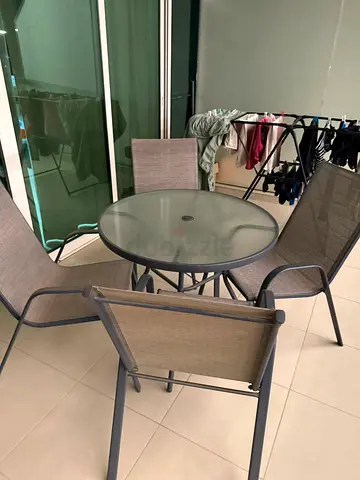 Outdoor glass-top table with 4 sling chairs - good condition