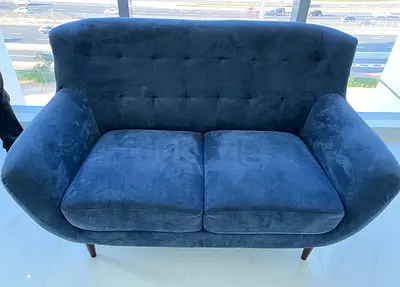 Two-seater navy blue velvet sofa in good condition