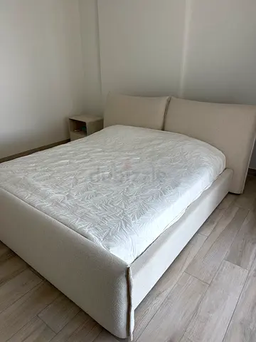 Beige upholstered double bed frame with headboard + sidetable