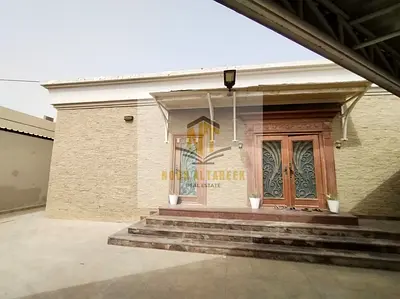 Two adjacent villas for sale in Al Ghafia, Sharjah, with a total area of ​​19,600 sq ft. The first villa features 6 bedrooms, a majlis, 2 living rooms