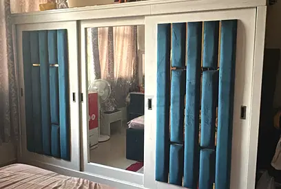 White Sliding Wardrobe with Mirrored Center and Padded Blue Panels