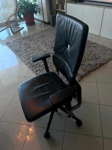 Black leather ergonomic office chair with armrests and wheels