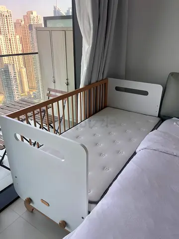 Convertible toddler bed / side-attach crib in white and wood