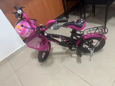 Childrens pink 14-inch bike with helmet and basket - very good condition- support tyres available