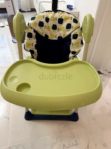 Green baby high chair with detachable tray and seat for infant. It was bought in Germany