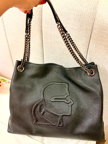 Black leather shoulder bag with chain straps and embossed profile logo