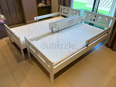 Two white single beds with side rails — sturdy wooden frames, like-new