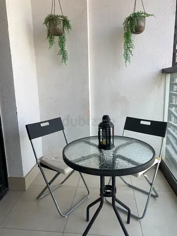 Glass-top bistro table with two folding chairs - compact balcony set
