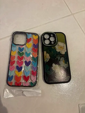 Two iPhone 14 Pro Max protective cases (floral + rainbow hearts)
