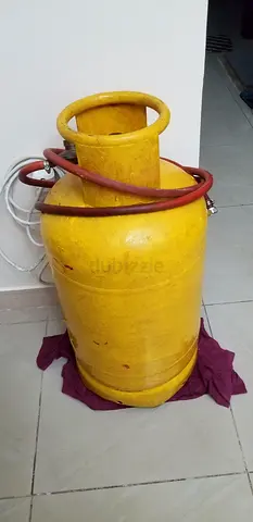 Used yellow LPG gas cylinder with regulator and hose